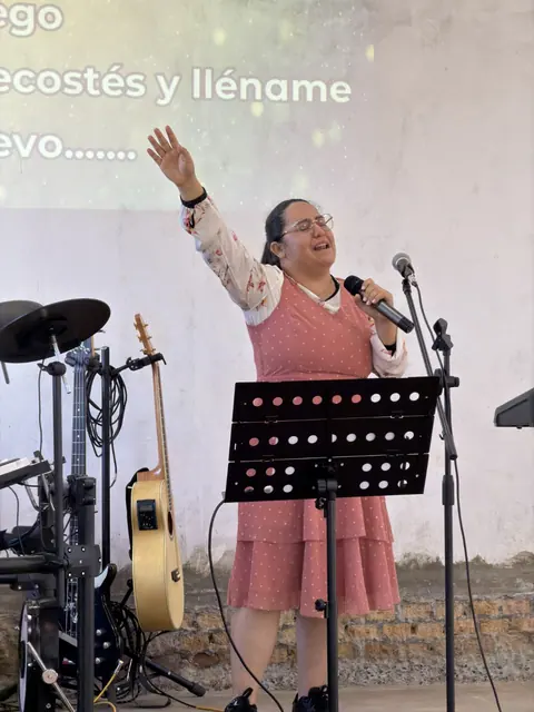 Momento de adoración durante un culto de la ADMFC