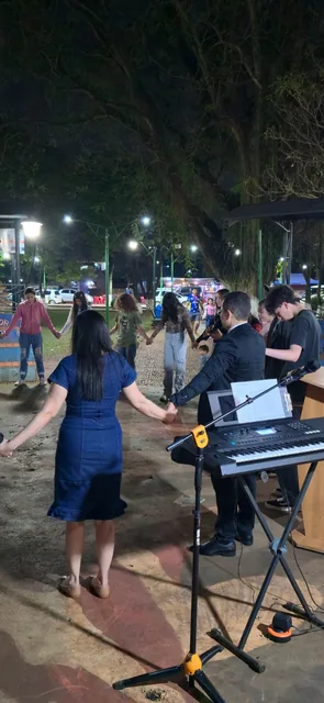 Oración comunitaria durante evangelismo en un espacio público